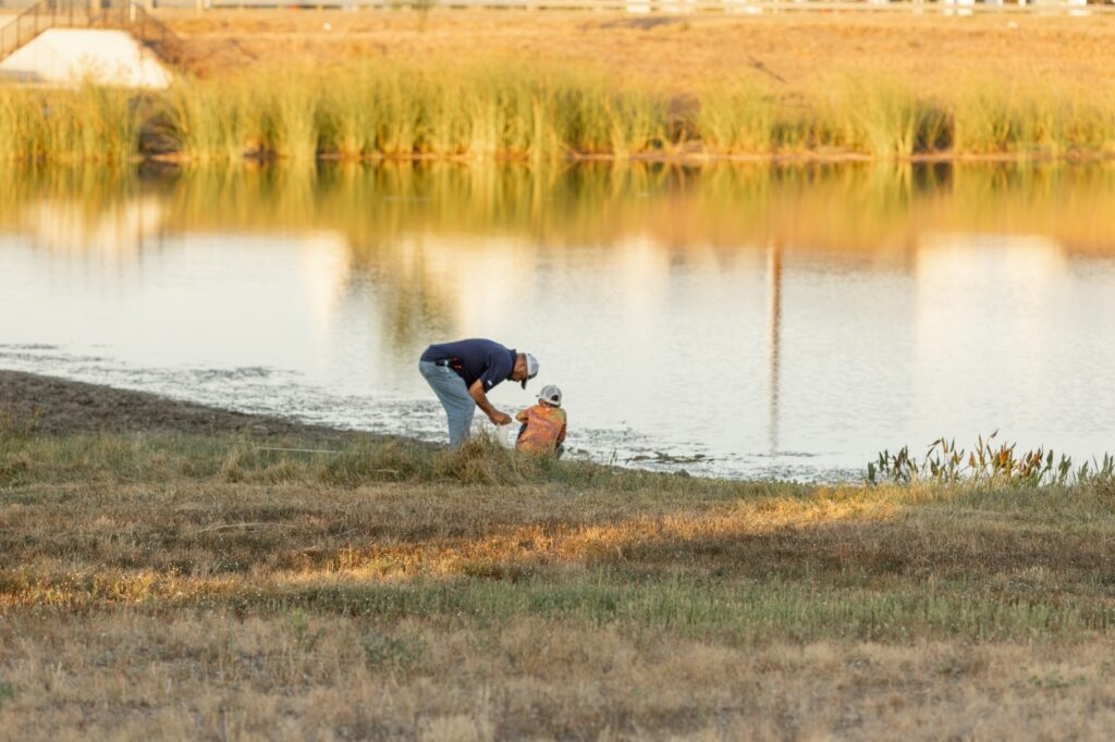 Man and boy at the side of a Goodnight Ranch pond